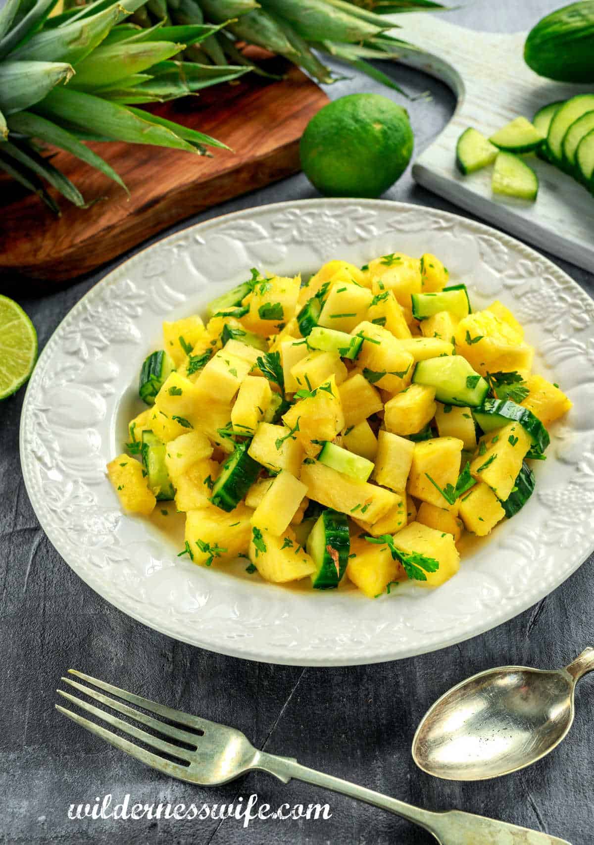 White bowl filled with Pineapple Cucumber Salad on a grey wood table